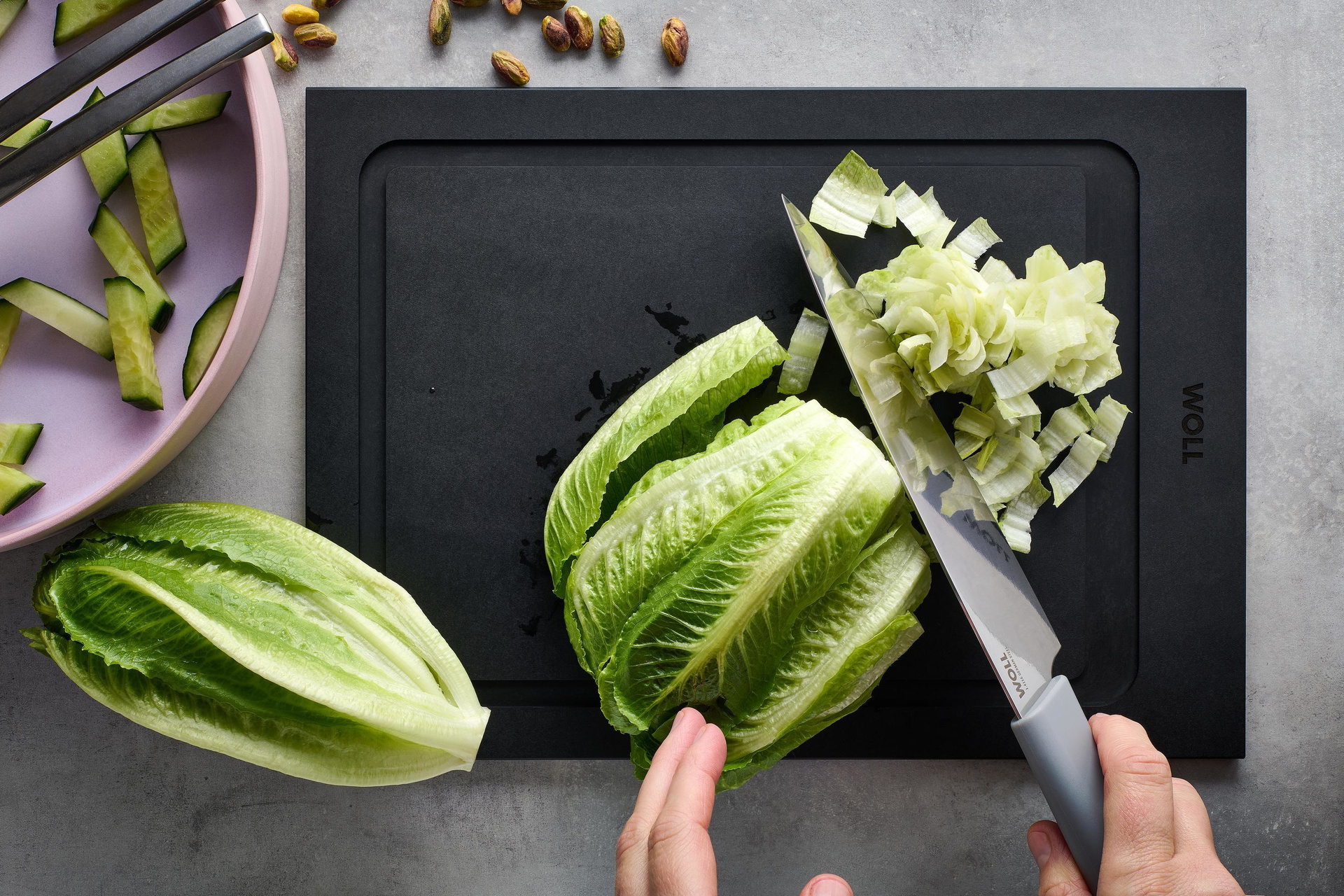 Auf einem Cut & Serve Schneidebrett wird mit einem Cutting Edge Messer Salat klein geschnitten. 