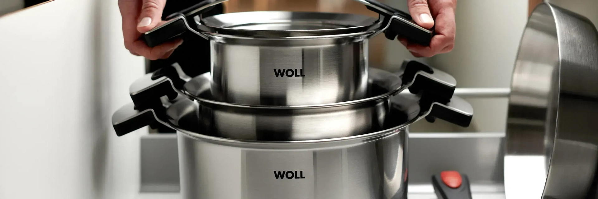 Die runden Töpfe der Serie Concept Pro stehen in einer ausgezogenen Schublade übereinander gestapelt, daneben liegt eine Pfanne mit abgenommenem Stiel.