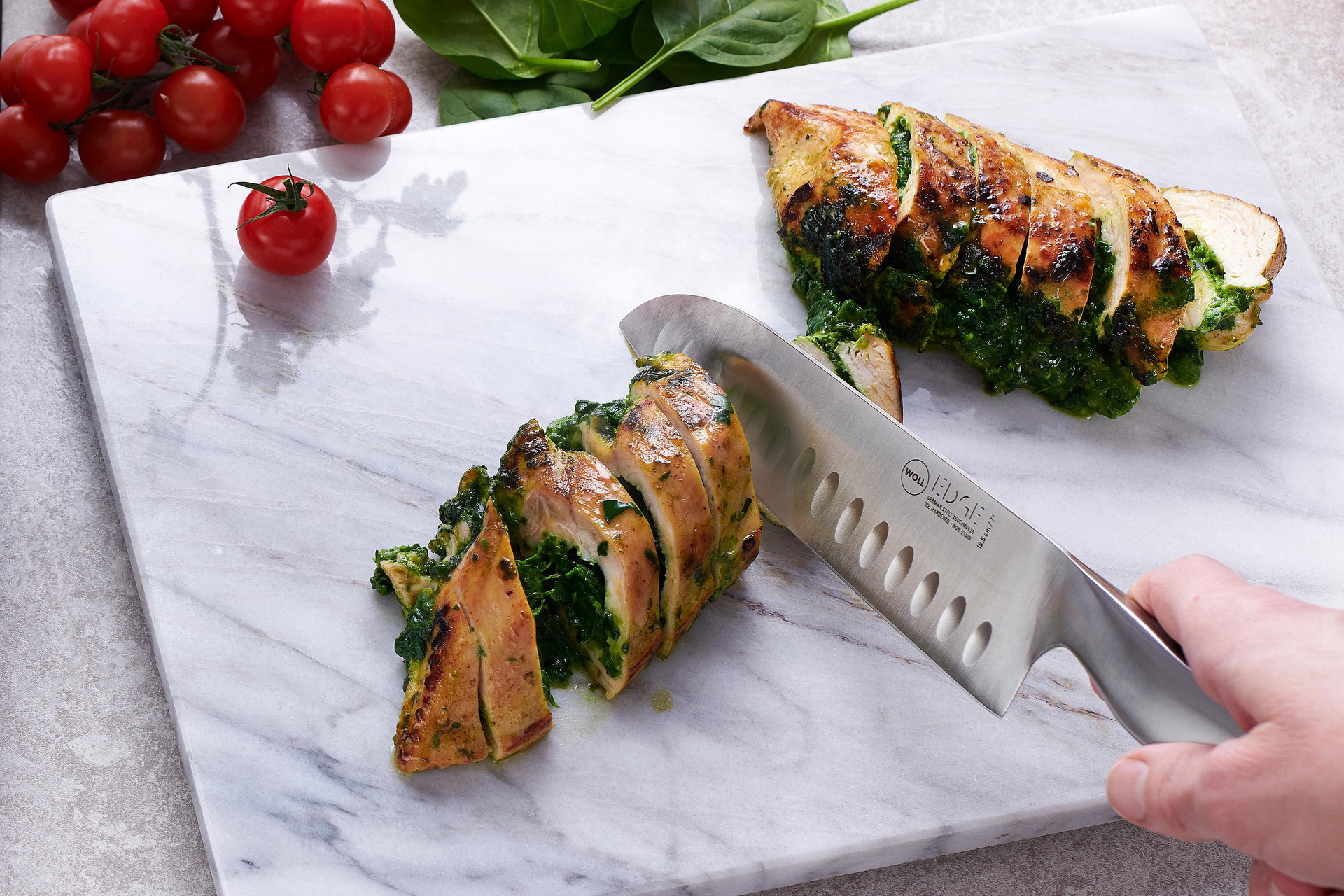 Edge Santokumesser Mit dem Edge Santokumesser wird eine mit Spinat gefüllte Fleischrolle in Portionsgrößen geschnitten.