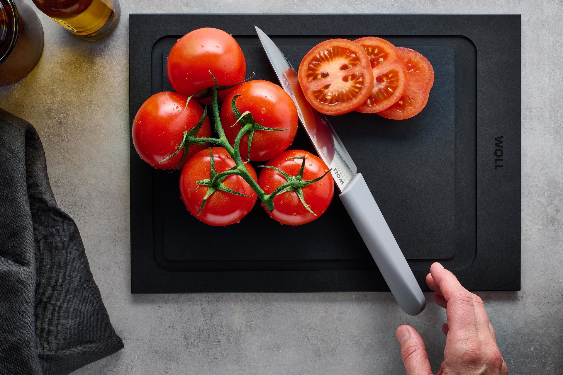 Mit dem Cutting Edge Messer werden Cherrytomaten auf einem Cut & Serve Schneidebrett halbiert.