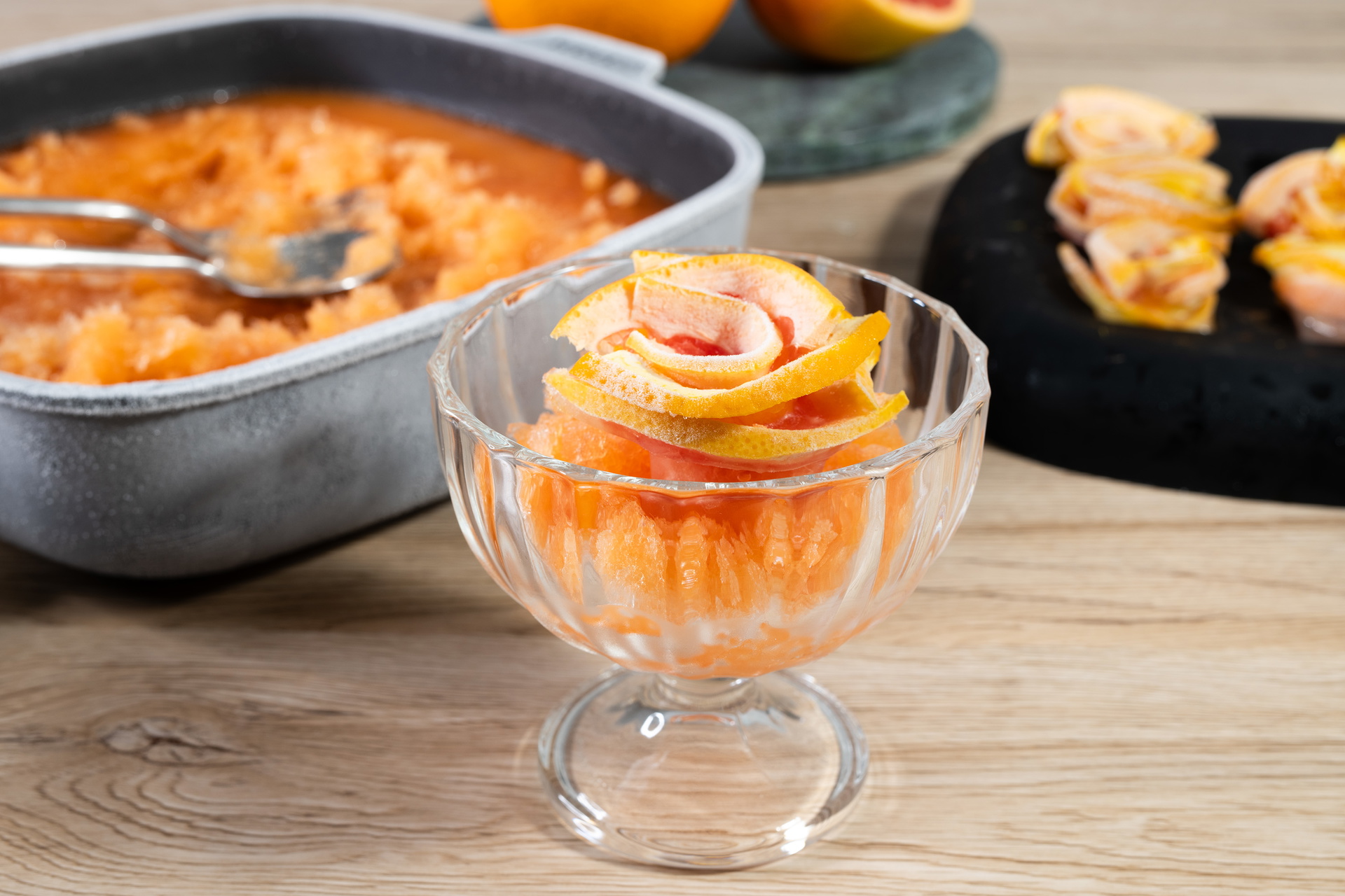 In einer viereckigen Diamond-Lite-Pfanne wurde der Aperol Spritz Grantia gekühlt. Ein Teil davon wurde in einem Glas serviert und mit einer Orangenrose garniert.