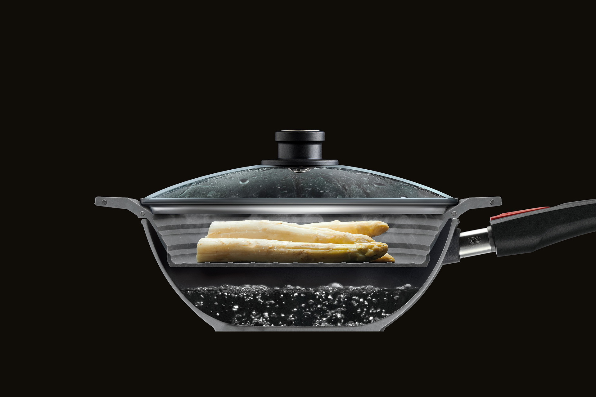 SI26F_Mood Im Querschnitt ist eine halbierte Wok Pfanne mit Glasdeckel zu sehen, in der Spargel mit dem Steam it multifunktionalen Silikoneinsatz gedämpft wird.