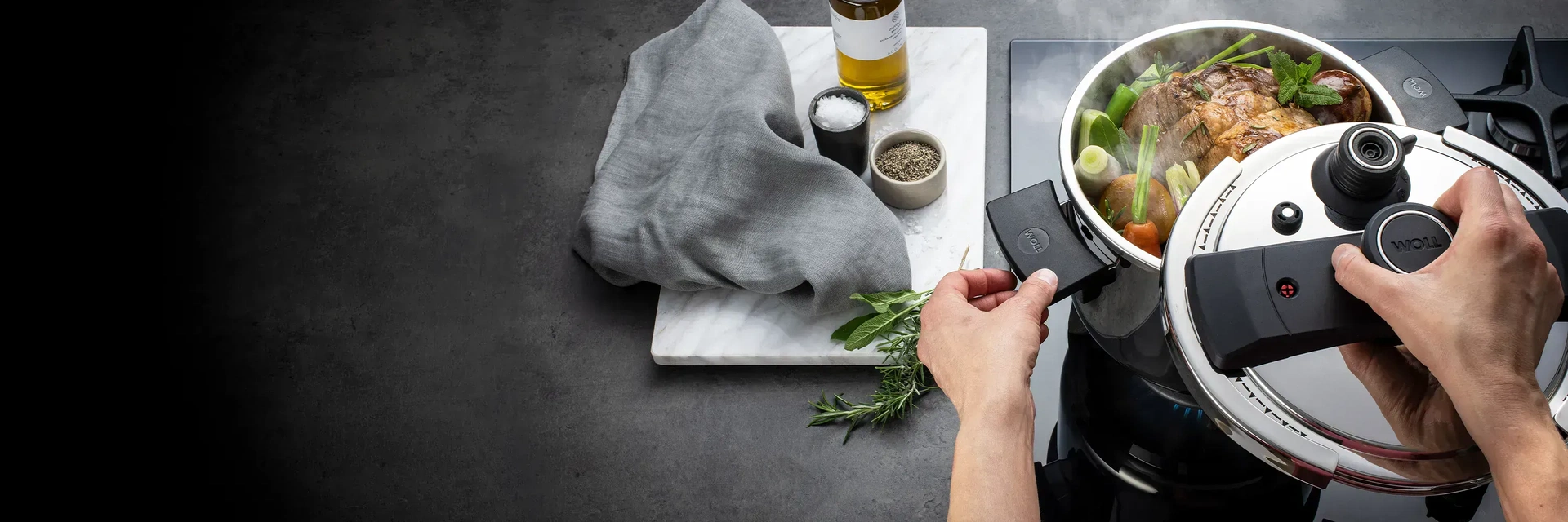 Im runden Schnellkopftopf der Serie Pressure Pro werden Fleisch und Gemüse zubreiten. Auf einem Brett daneben befinden sich noch Öl, Salz, Pfeffer, ein Tuch und Gewürze.