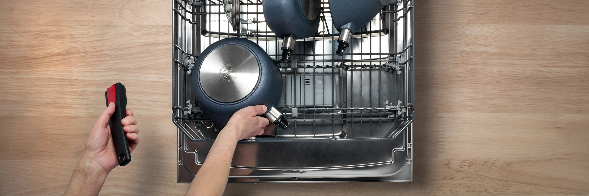 In der Spülmaschine werden verschiedene Geschirre der Serie Diamond Lite mit abgenommenem Stiel dargestellt. Der passende Pfannenstiel ist griffbereit.