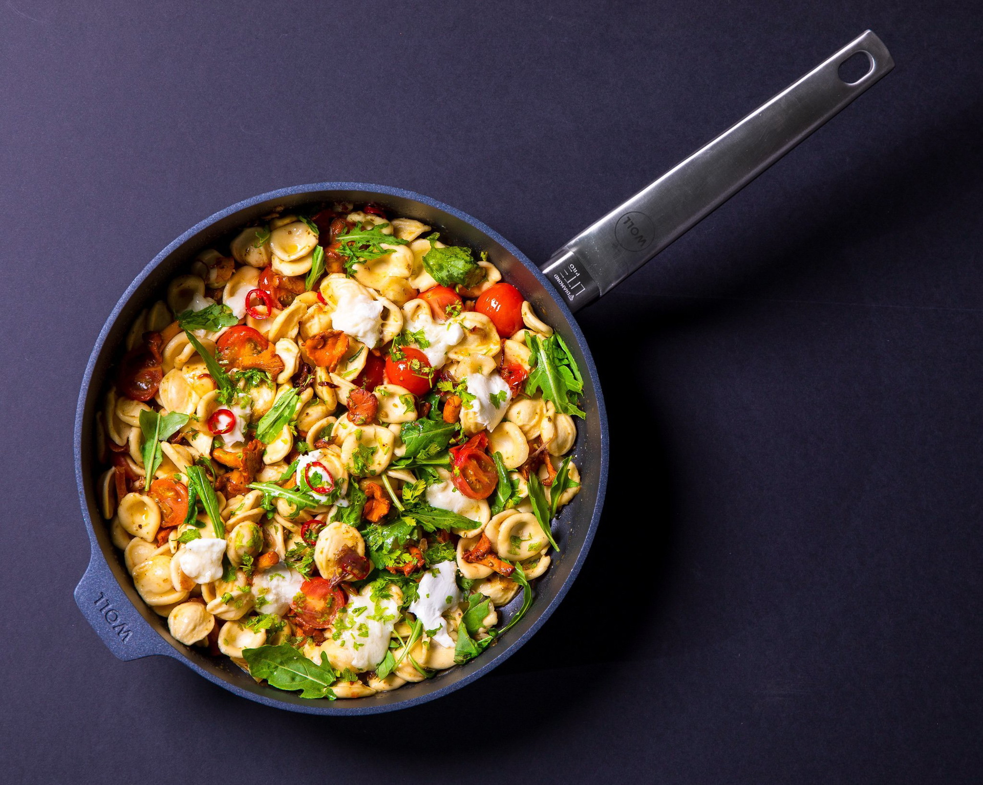 In einer runden, heißen Pfanne der Serie Diamond Lite Pro befindet sich frisch zubereitetes Orecchiette mit Pfifferlingen.