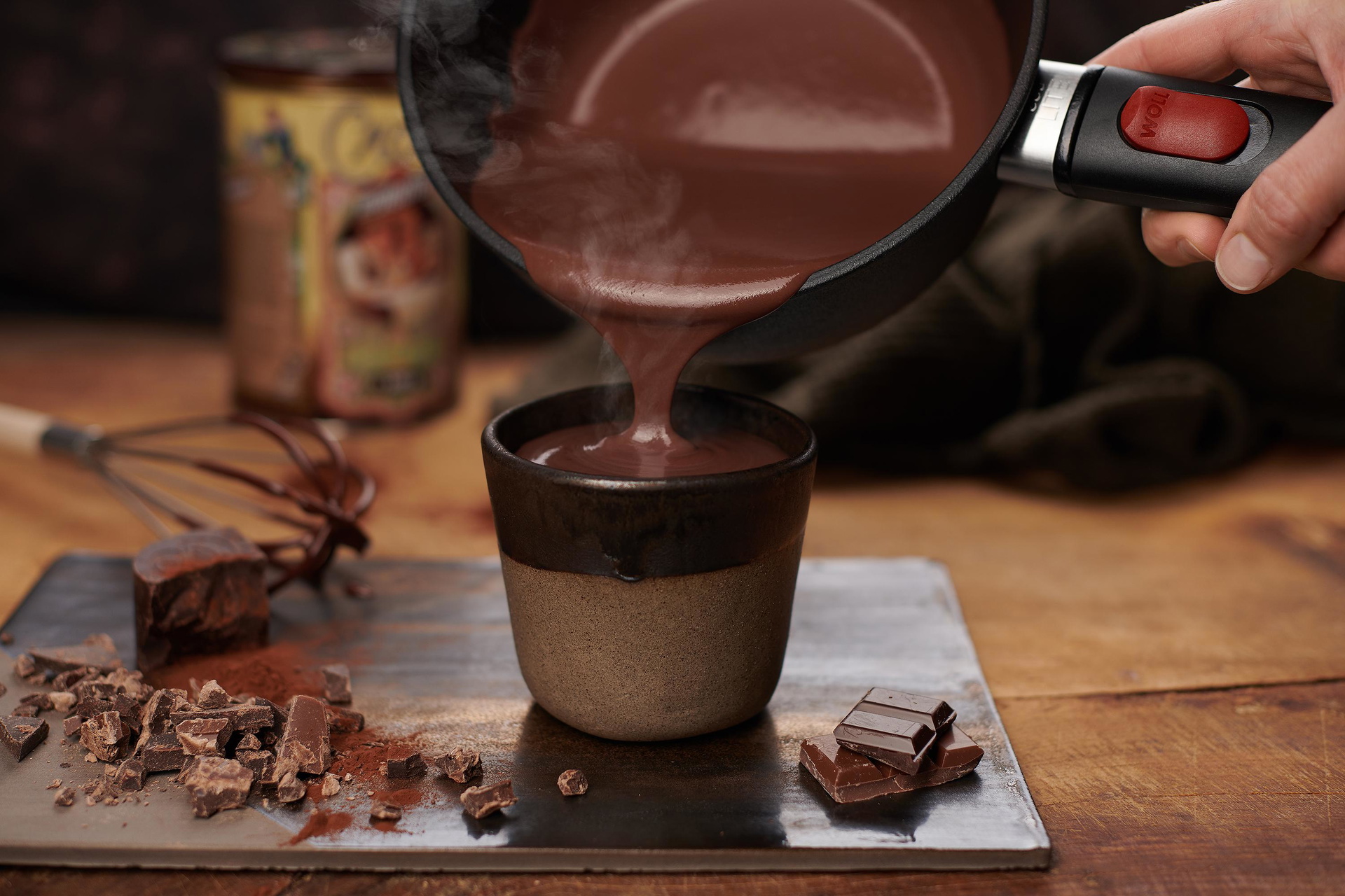 1918ELI_Mood Aus einem runden Eco Lite Stieltopf wird heiße Trinkschokolade in eine Tasse gefüllt.