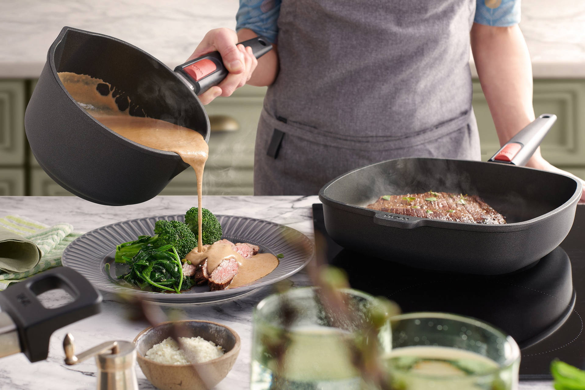 In der viereckigen Nowo Titanium Pfanne mit abnehmbarem Stiel wird ein Flank-Steak scharf angebraten. Parallel dazu wird aus dem Nowo Titanium Stieltopf eine warme Bourbon-Sahnesauce auf einen bereits portionierten Teller gegossen. Auf dem Teller liegt ei