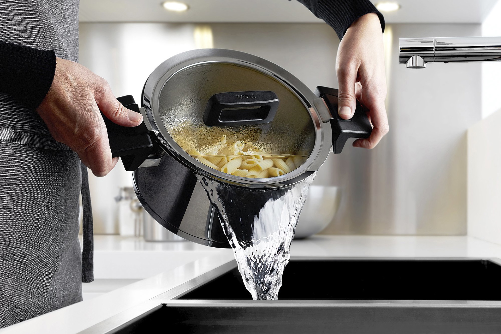 Das Nudelwasser wird aus dem Concept Topf in die Spüle gegossen. Durch die angehobene Position des Glasdeckels ist ein sicheres Abgießen möglich.