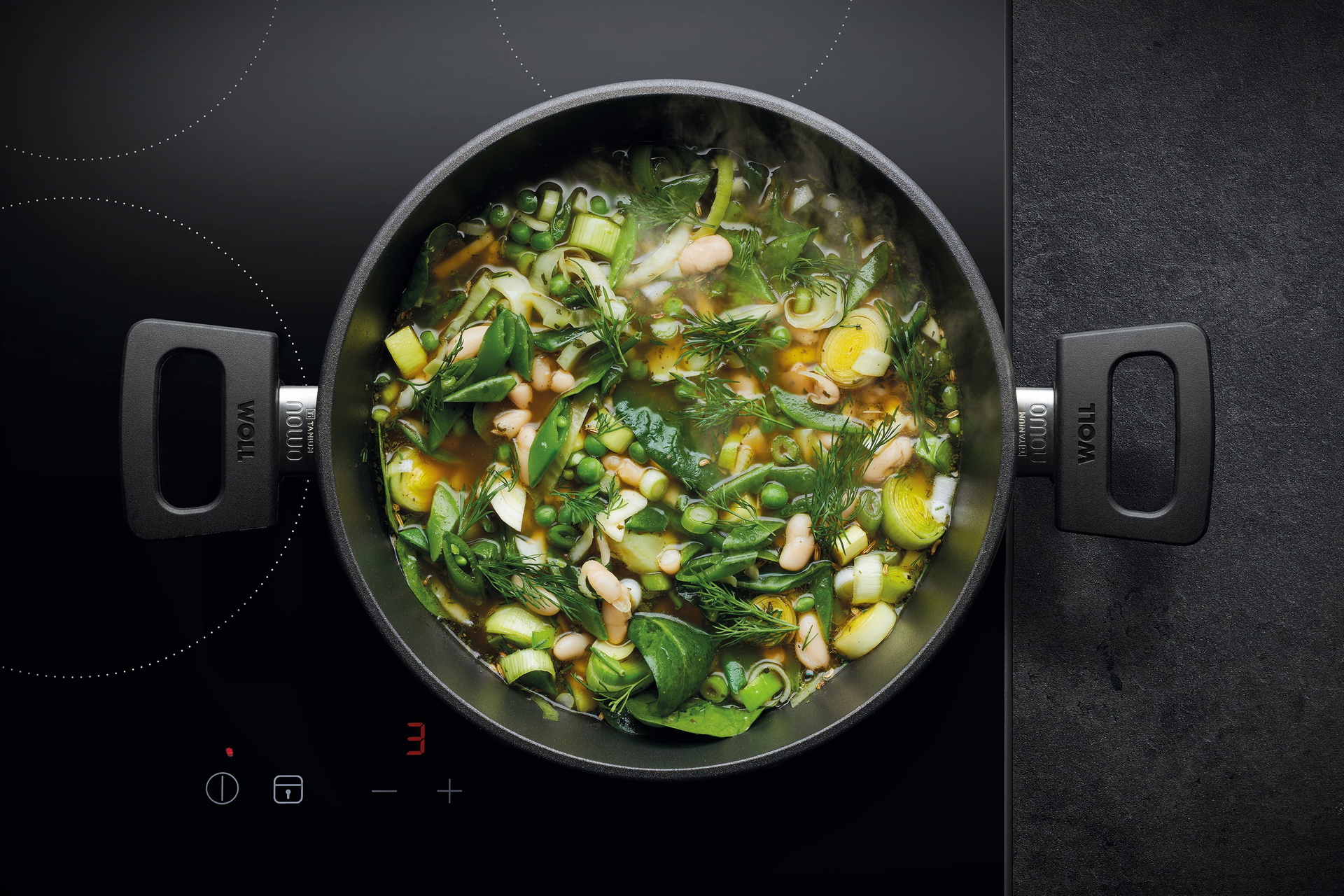 Auf dem Herd steht ein runder, heißer Topf Serie Nowo. Darin befindet sich eine frisch zubereitete italienische Frühlingssuppe.