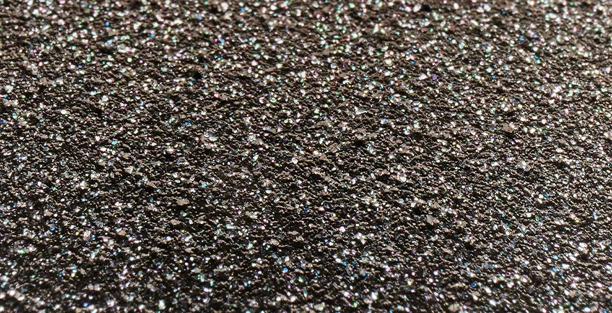 Eine Makroaufnahme einer PFAS-freien Beschichtung, die sich durch ihre außergewöhnliche Härte und Rauheit auszeichnet. Die einzigartigen Röstaromen entstehen aufgrund der ultrarauen Oberfläche.