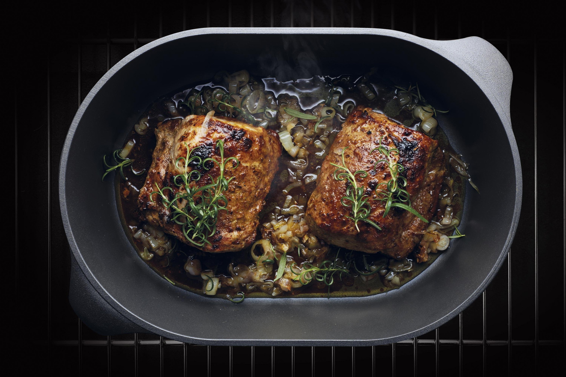 Auf dem Rost steht ein Titan Best Bräter ohne Glasdeckel in der Fleisch zubereitet wird. 