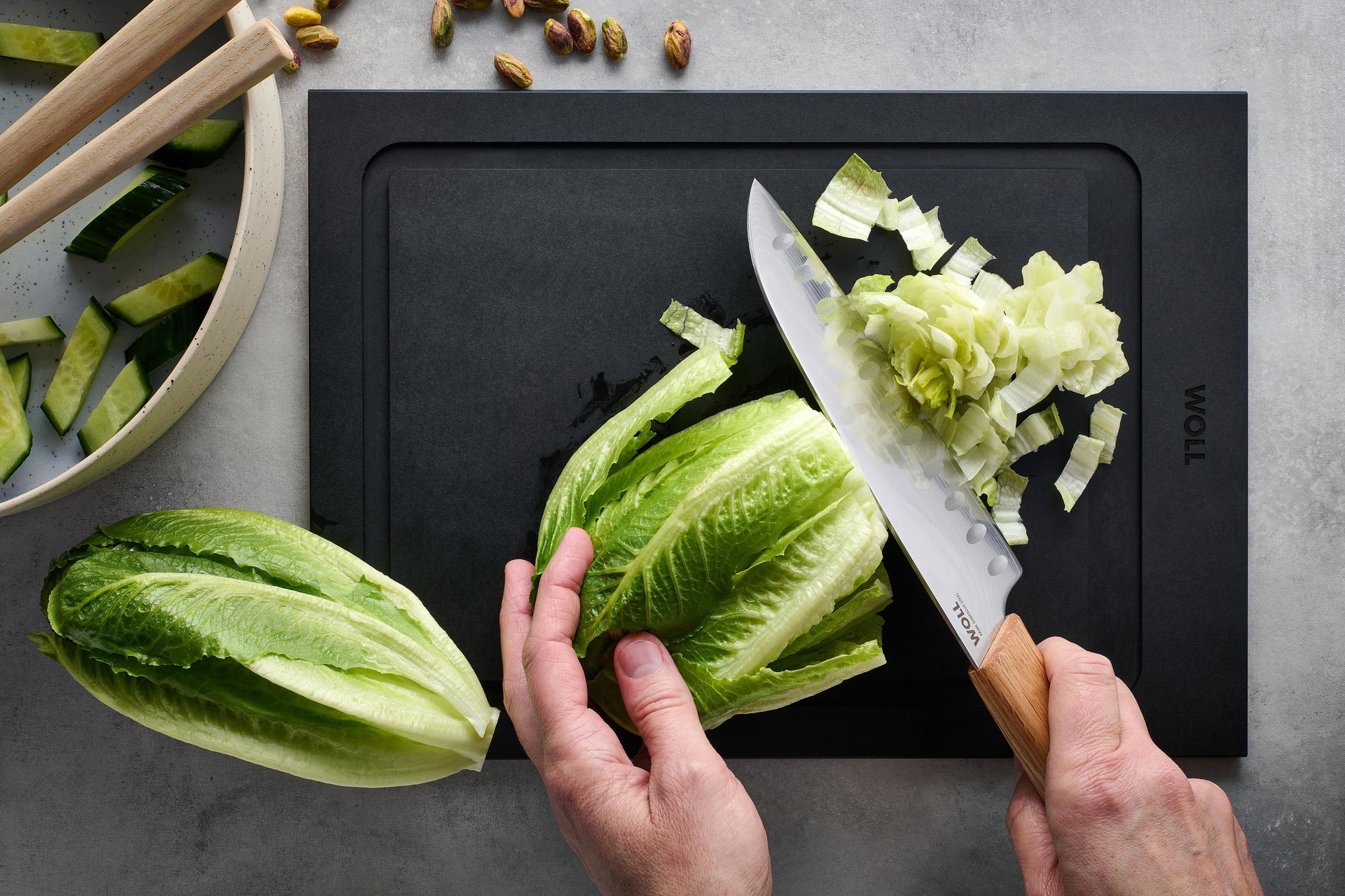 Mit dem Prime Edge Santokumesser wird ein Salatkopf auf einem Schneidebrett kleingeschnitten.