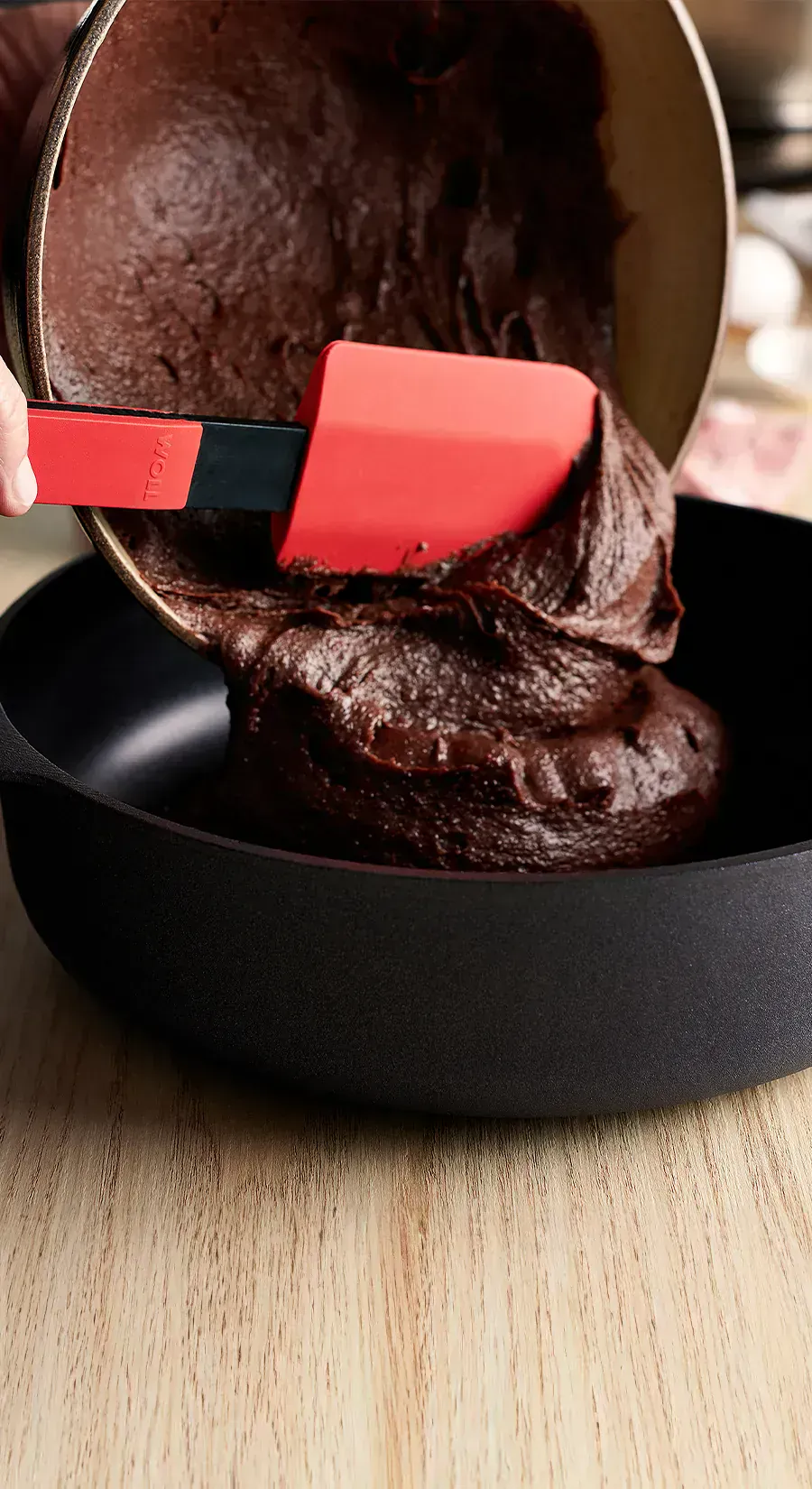 Der Kuchenteig wird mit dem Cook-it-Teigschaber aus der Schüssel direkt in die Diamond Lite Hochrandpfanne gegeben.