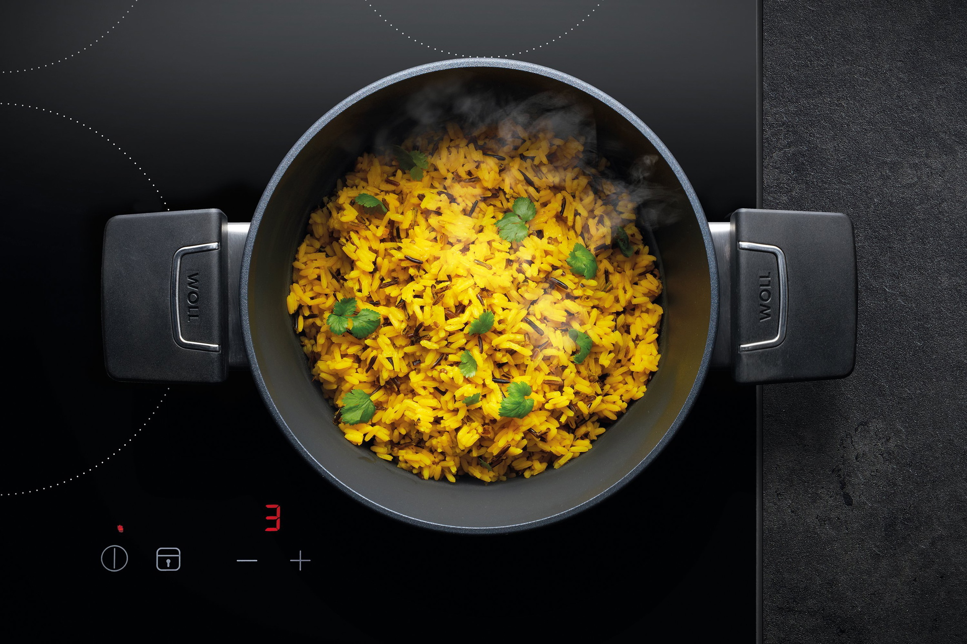 In einem runden, heißen Diamond-Lite-Topf mit abgenommenem Deckel befindet sich dampfender Safran-Wildreis mit Petersilie.