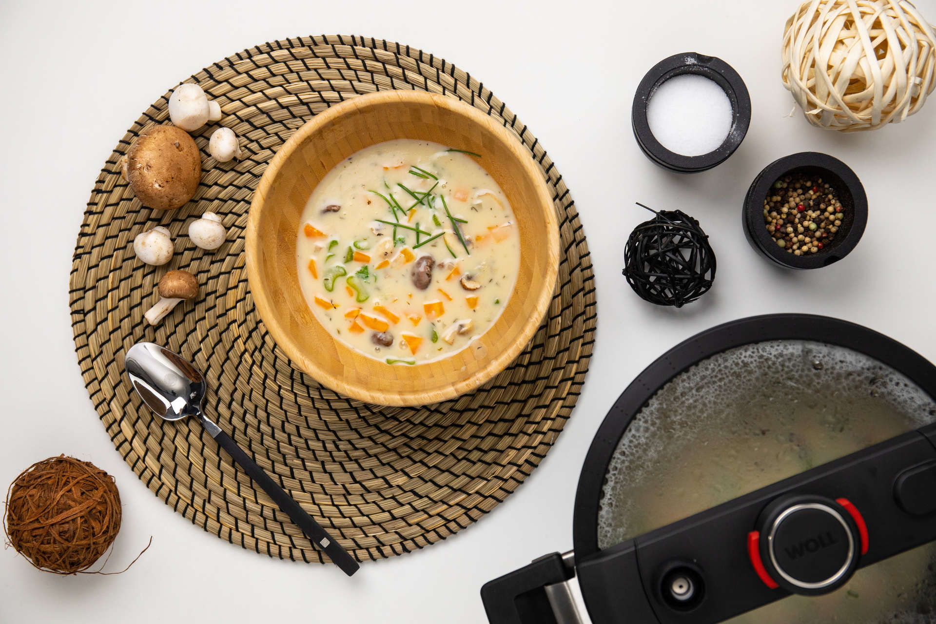 In einer runden Schüssel befindet sich frisch gekochte, cremige Pilzsuppe mit Reis. Daneben steht der runde Niederdrucktopf der Serie Diamond Active Lite, in dem die Suppe zubereitet wurde.