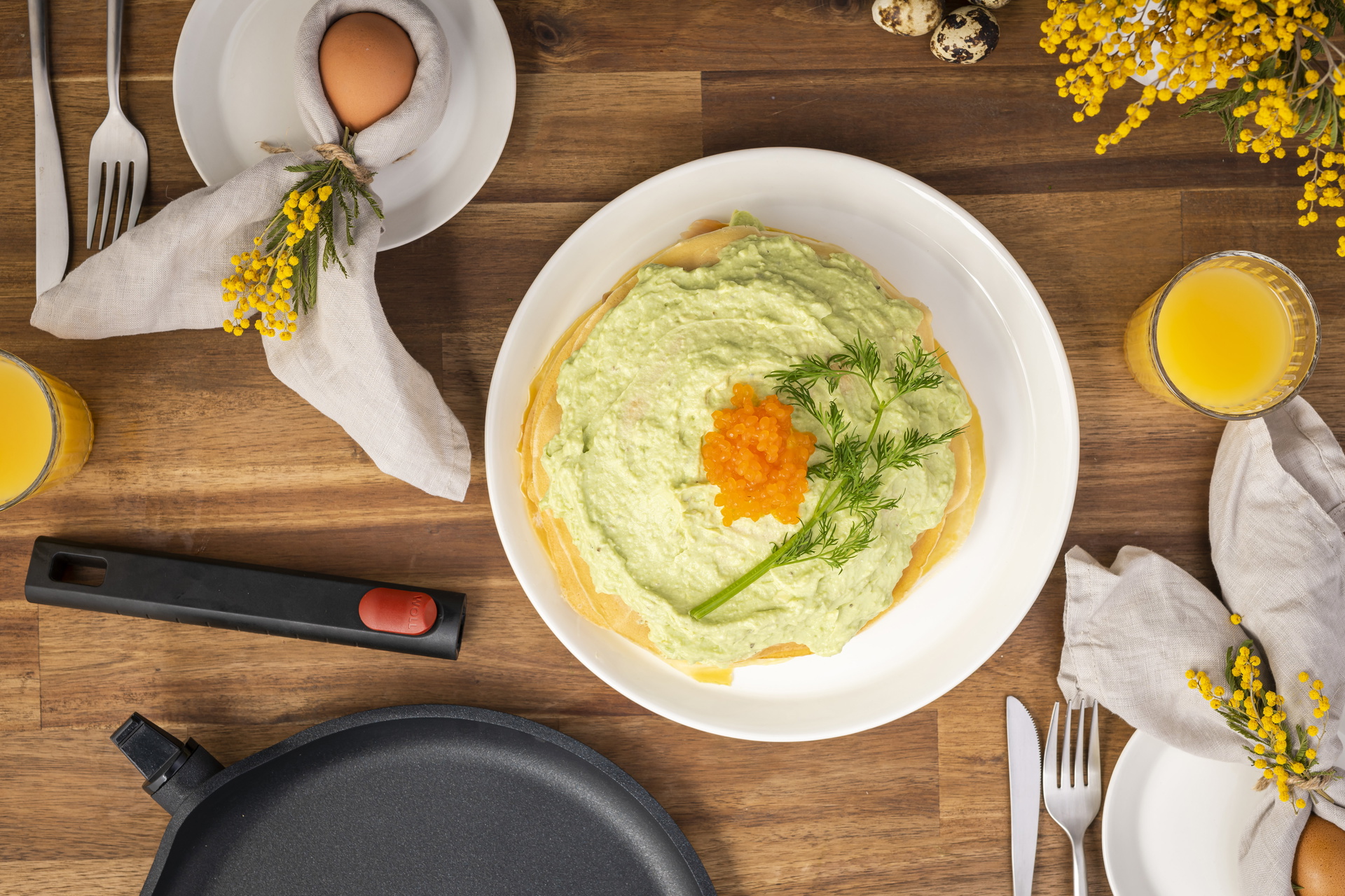 Auf einem Teller liegt eine Avocado-Lachs-Crêpe-Torte, darunter liegt eine runde Logic XR Pfanne mit abgenommenem Stiel.