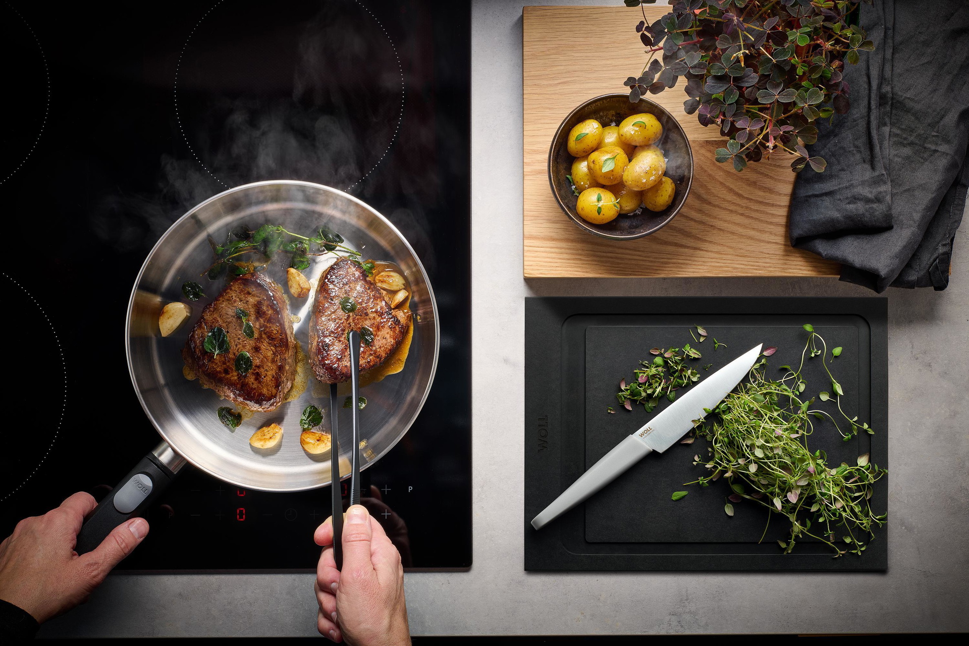 Auf dem Herd steht eine runde Logic Steel Pfanne, in der Fleisch angebraten und gewendet wird. 