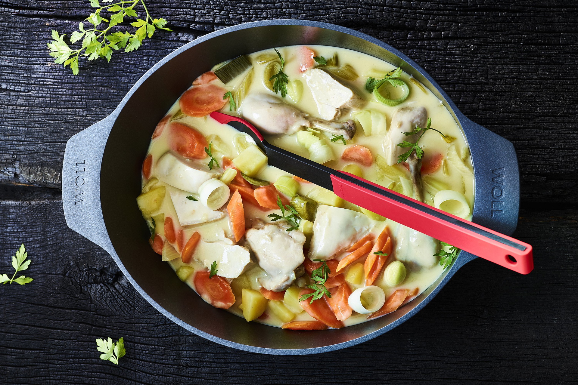 In einem heißen Bräter der Serie Diamond Lite befindet sich frisch zubereites beschwipstes Huhn mit Kartoffeln, Lauch und Karotten.