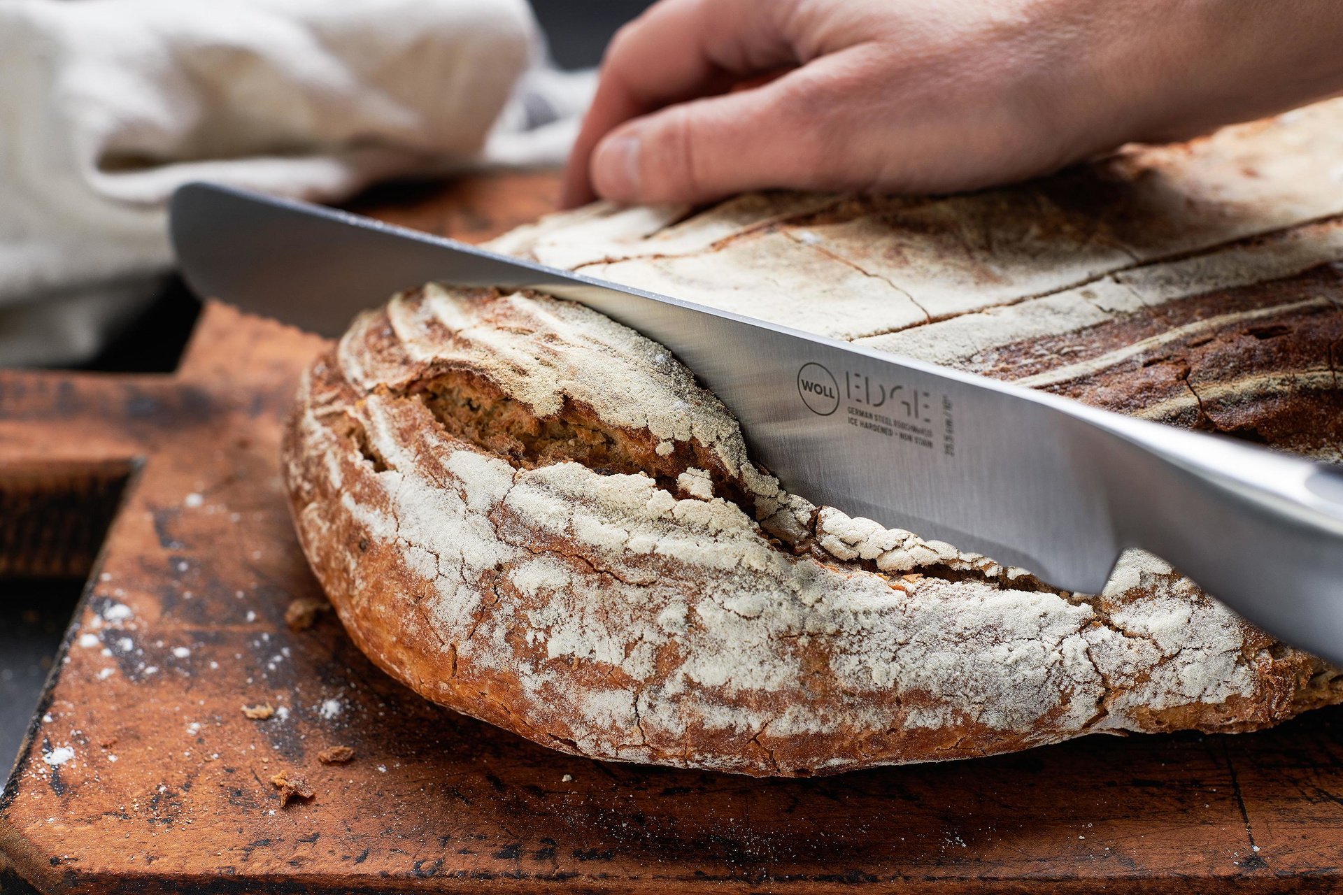 Edge Brotmesser Ein Brotlaib wird mit einem Brotmesser der Serie Edge angeschnitten.