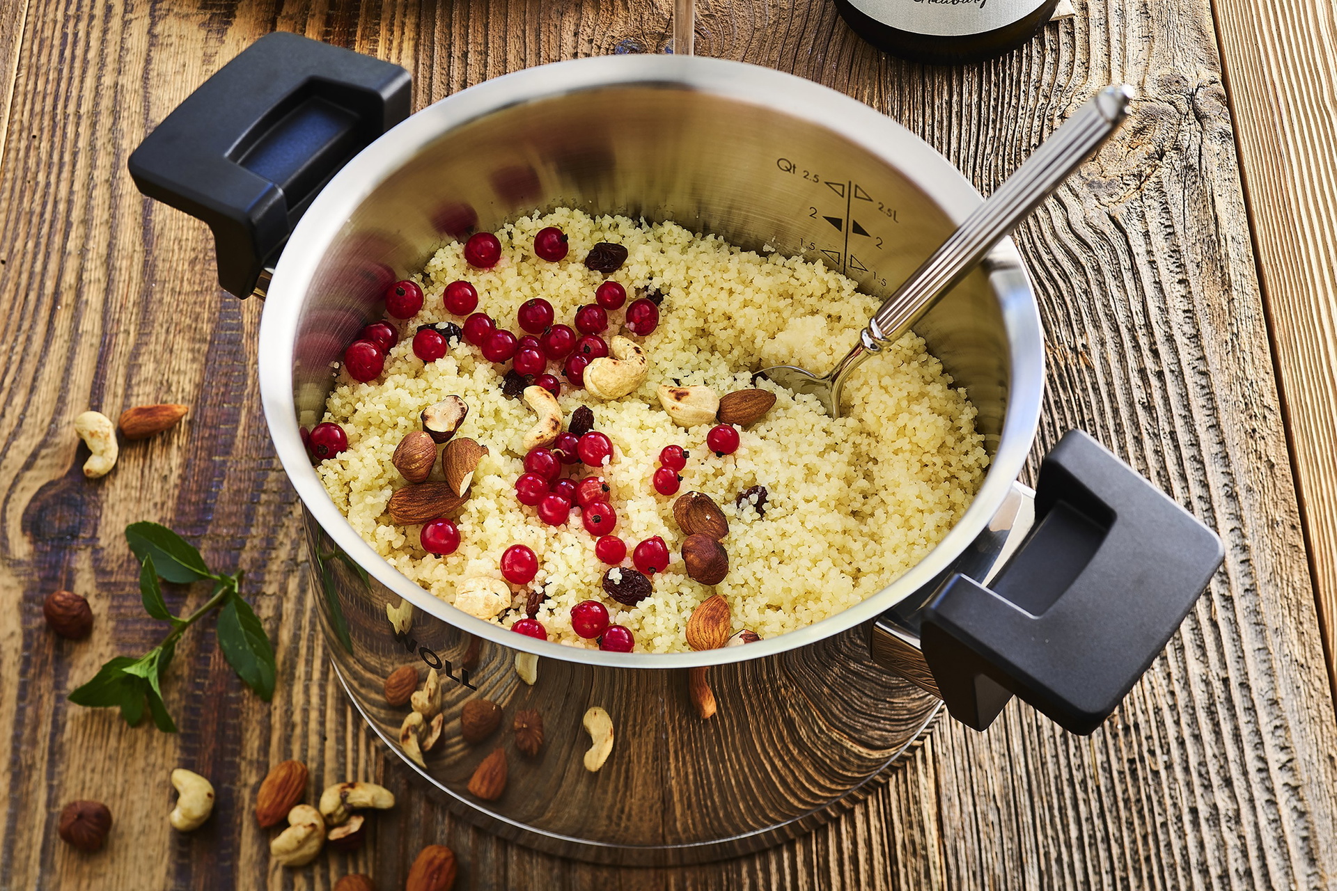 In einem runden, heißen Concept Topf befindet sich süßer Couscous mit Nüssen und Johannisbeeren.