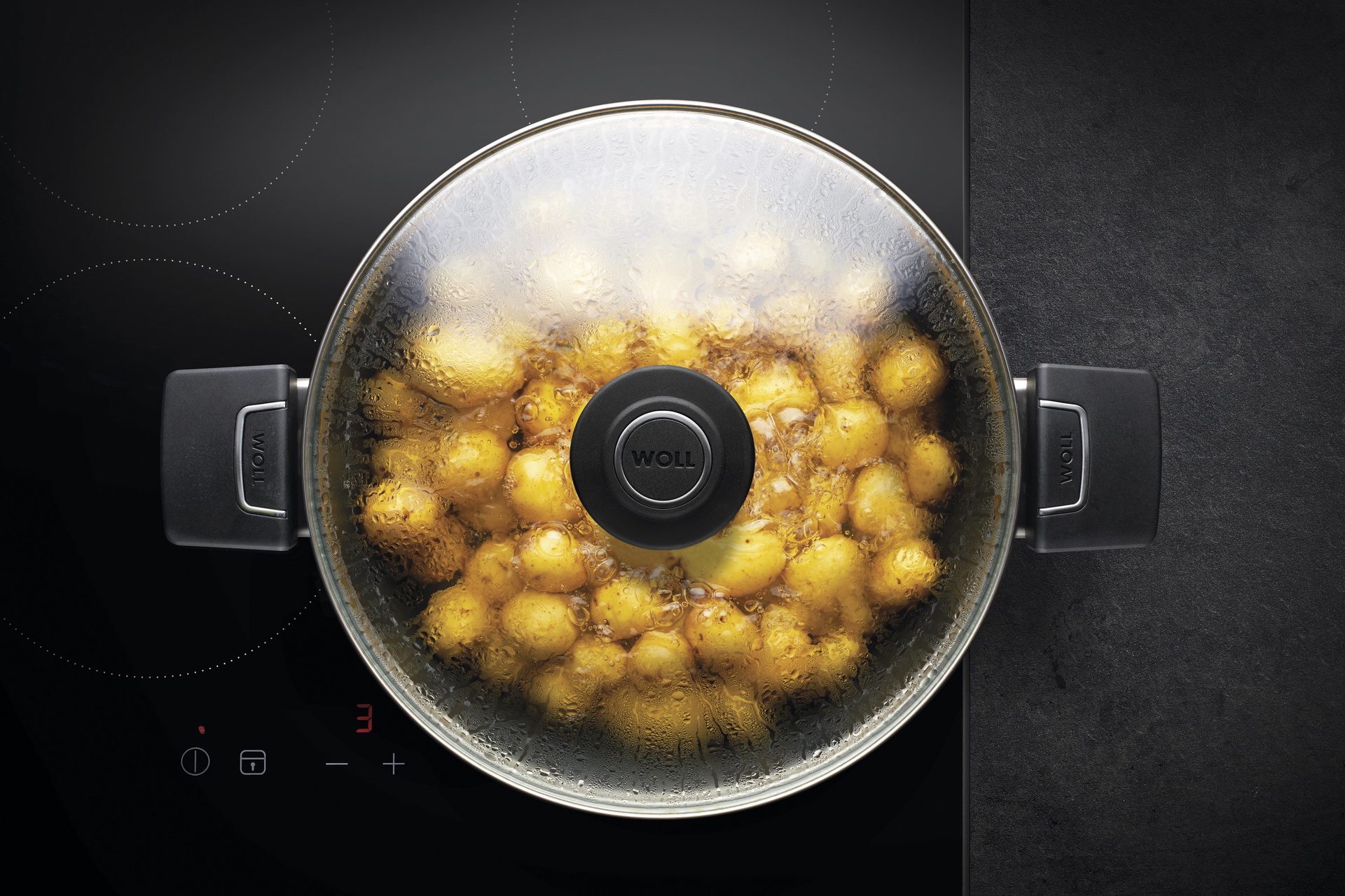 Auf dem Herd steht ein runder Diamond Lite Topf, in der sich ein dampfendes Gericht befindet. Am Glasdeckel hat sich Kondenswasser gebildet.