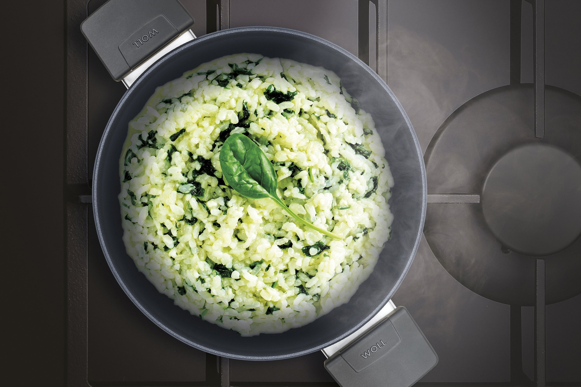 Auf dem Herd steht ein heißer, runder Diamond-Lite-Topf mit frisch zubereitetem, dampfendem Risotto mit Spinat und Estragonschaum.