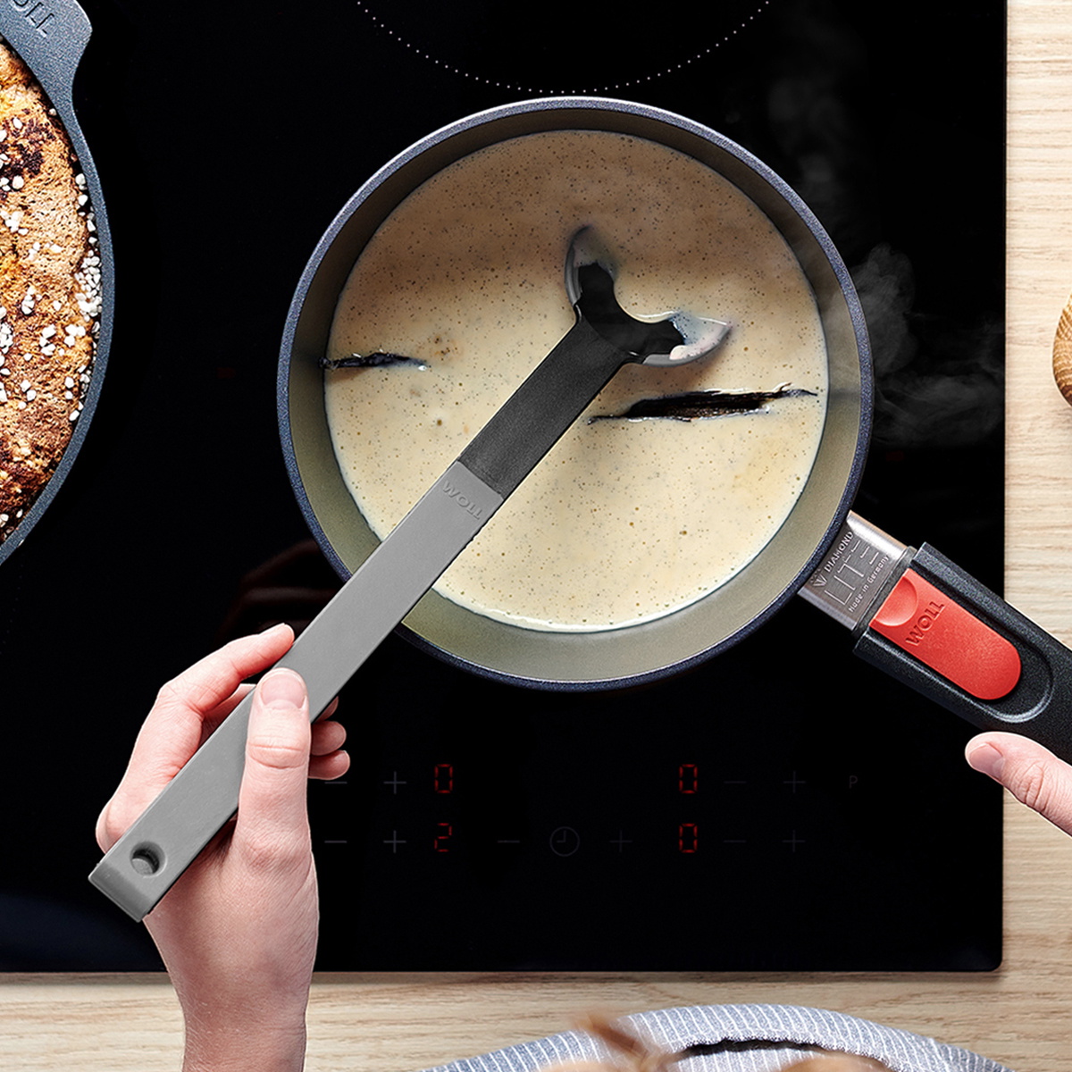 In einem runden Diamond Lite Stieltopf wird Vanillesauce gekocht und mit einem grauen Cock it Lochlöffel umgerührt.