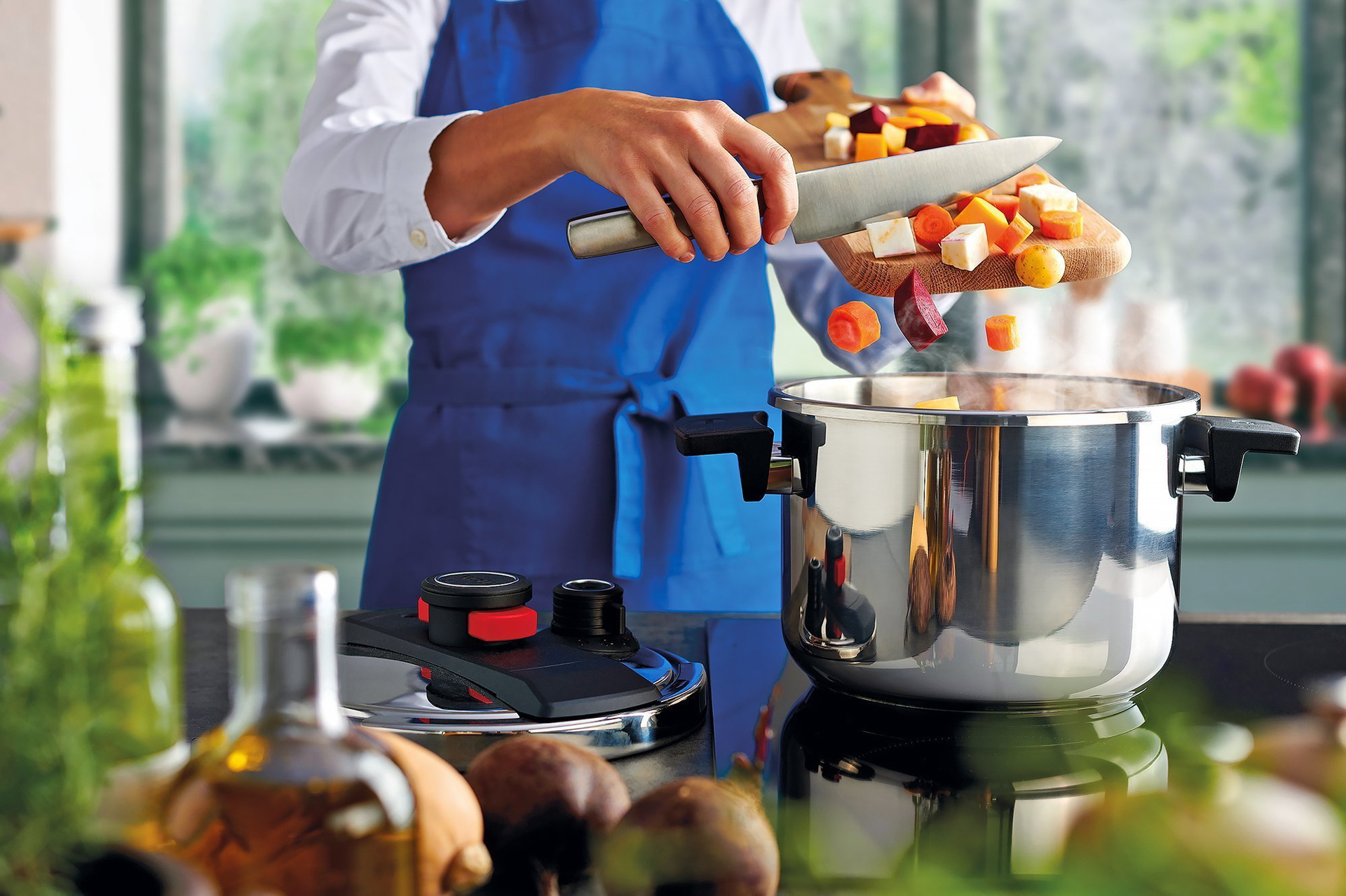 Gemuese_122PP_RGB Auf dem Herd steht ein Pressure Pro Schnellkochtopf, in den frisch geschnittenes Gemüse gegeben wird.