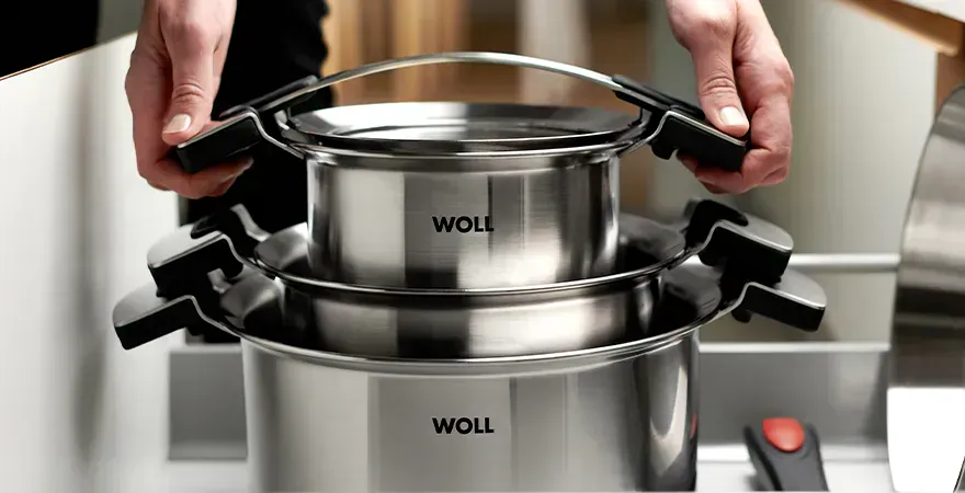 In einer ausgezogenen Schublade stehen im Hintergrund die runden Töpfe der Serie Concept Pro übereinander gestapelt, daneben liegt eine Pfanne mit abgenommenem Stiel.