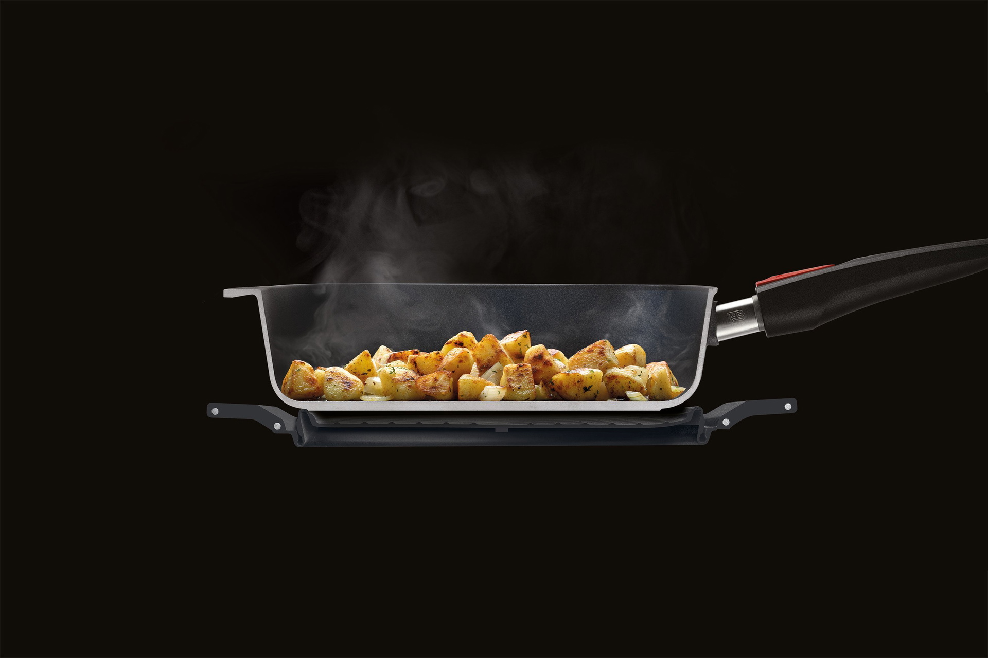 Im Querschnitt ist eine runde, dampfende Pfanne dargestellt, die auf dem Steam it multifunktionalen Silikoneinsatz steht.