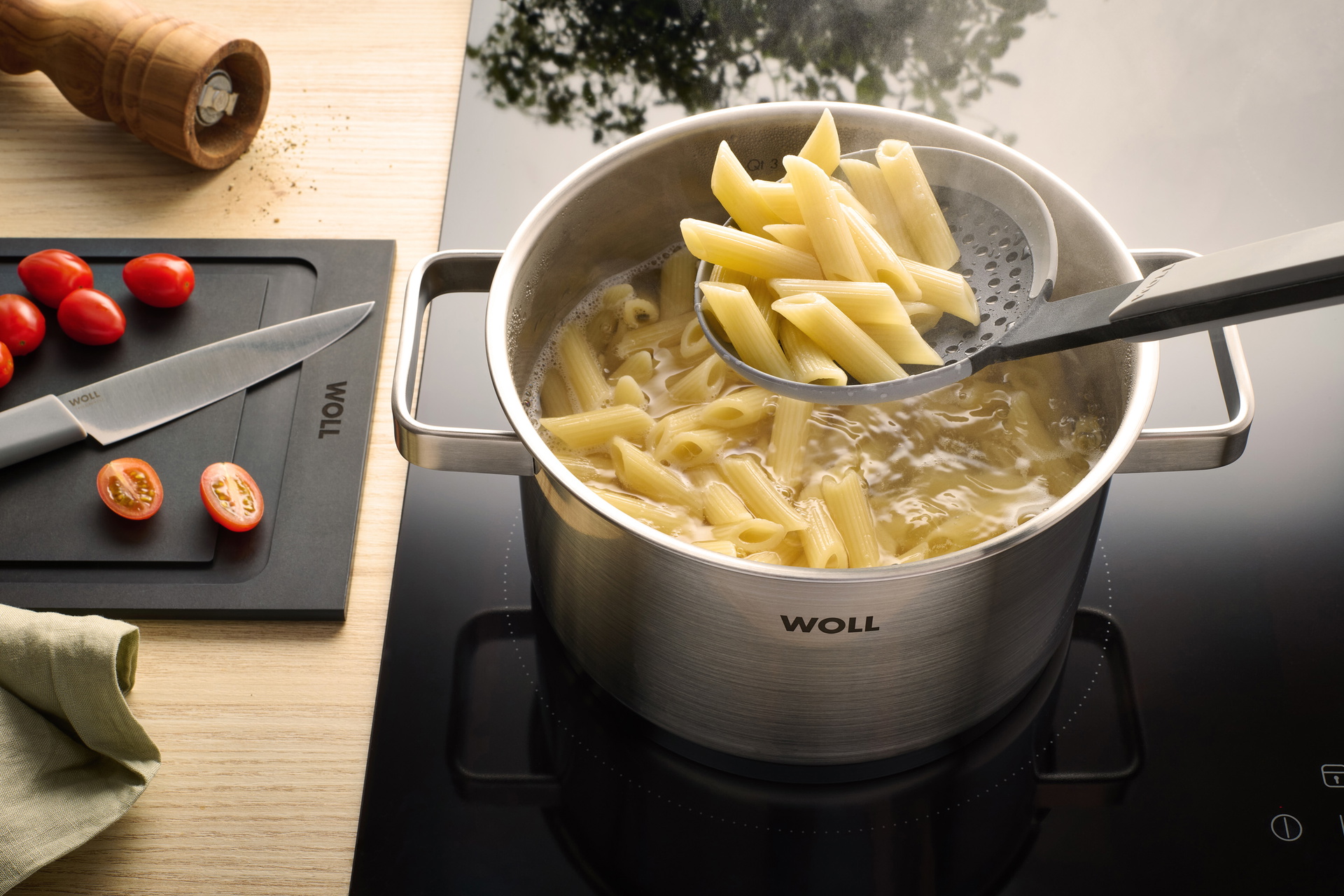 Mit einem Steam it Schaumlöffel werden Nudeln aus einem Steel Topf entnommen.