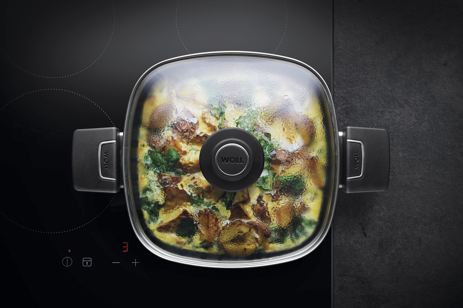 Auf dem Herd steht eine viereckige Diamond Lite Kasserolle, in der sich ein dampfendes Gericht befindet. Am Glasdeckel hat sich Kondenswasser gebildet.