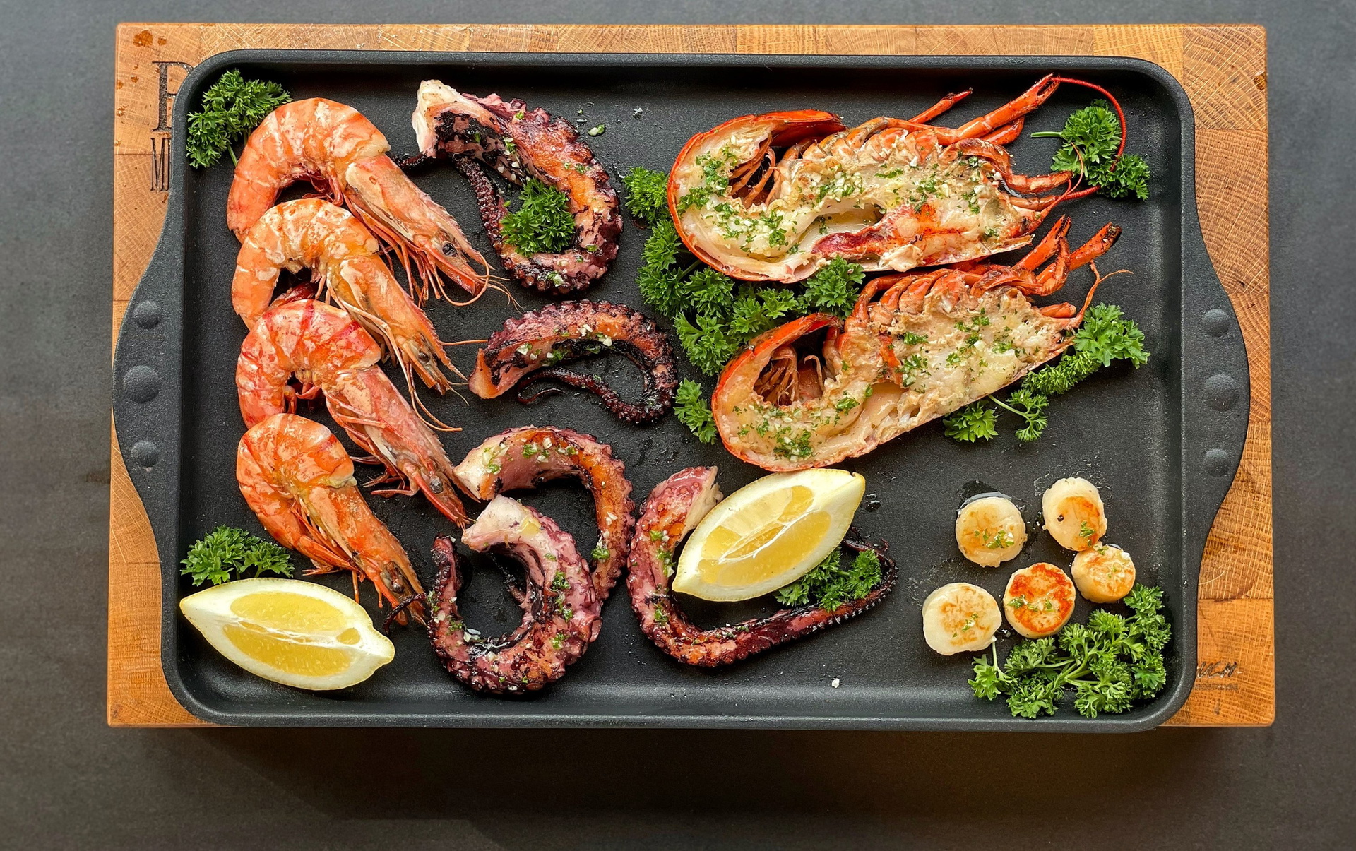 Auf einer heißen Grillplatte bzw. Teppan-Yaki-Platte der Serie Titan Best befindet sich frisch angebratenes Seafood.