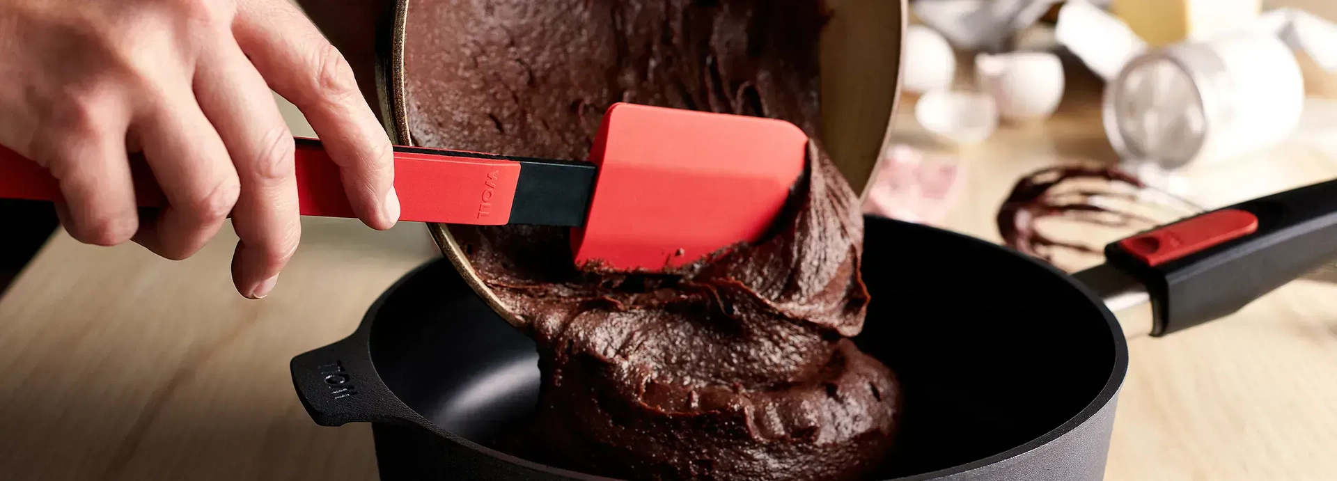 Der Kuchenteig wird mit dem Cook-it-Teigschaber aus der Schüssel direkt in die Diamond Lite Hochrandpfanne gegeben.