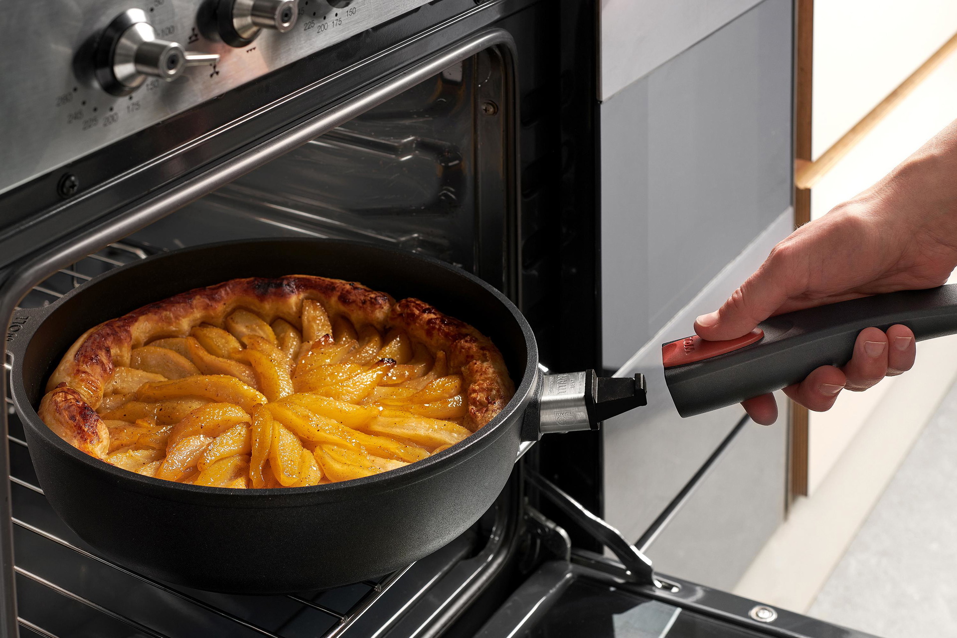 Auf dem Rost steht eine runde Titan-Best-Pfanne mit einem gebackenen Kuchen. Um die Pfanne aus dem Ofen zu entnehmen, wird der Stiel eingerastet.