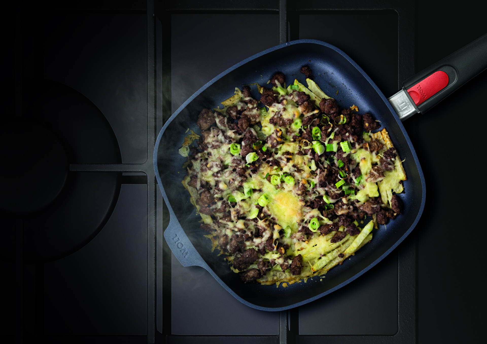 Auf dem Herd steht eine viereckige, heiße Diamond-Lite-Pfanne mit abnehmbarem Stiel. Darin befindet sich frisch zubereitetes, dampfendes Hackfleisch-Kohlrabi.