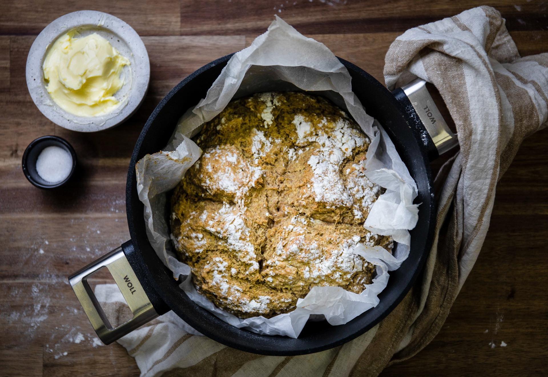 In einem Logic-Topf ist frisch gebackenes Sodabrot. Daneben steht eine Schüssel Salz und ein Teller mit weicher Butter.