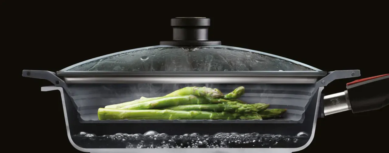 Um den Dampfgarprozess mit grünem Spargel und dem multifunktionalen Silikoneinsatz der Serie Steam it zu veranschaulichen, wurde der Topf in der Mitte durchgeschnitten.